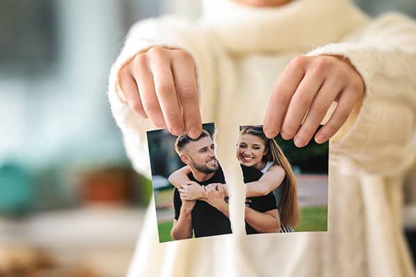 Woman tearing up photo of happy couple