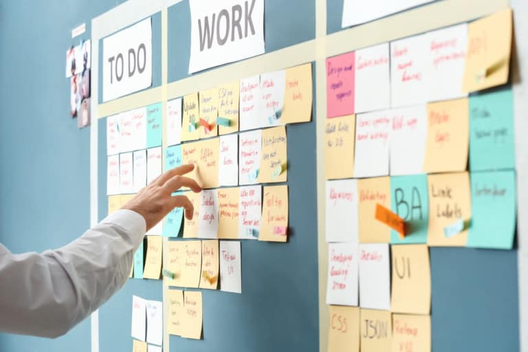 Young man near scrum task board in office